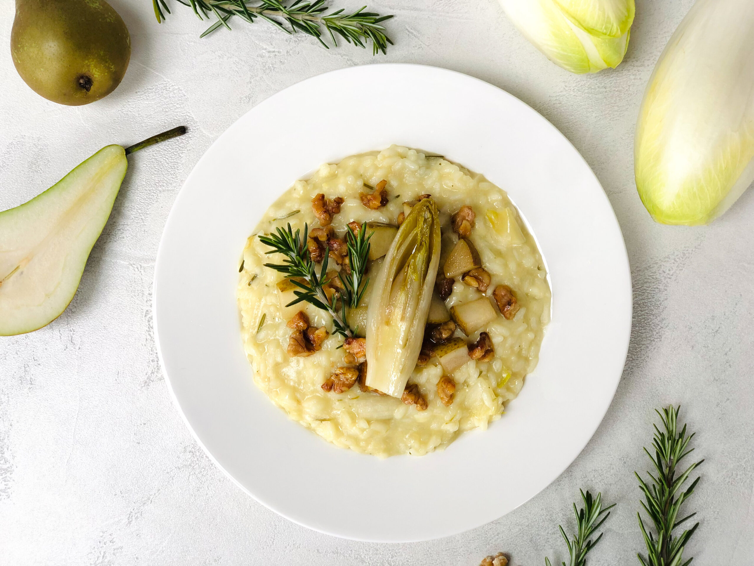 Chicorée Risotto mit Rosmarin: getoppt mit karamellisierten Walnussstückchen, gebratenen Birnenstückchen und gebratenem Chicorée (vegan)